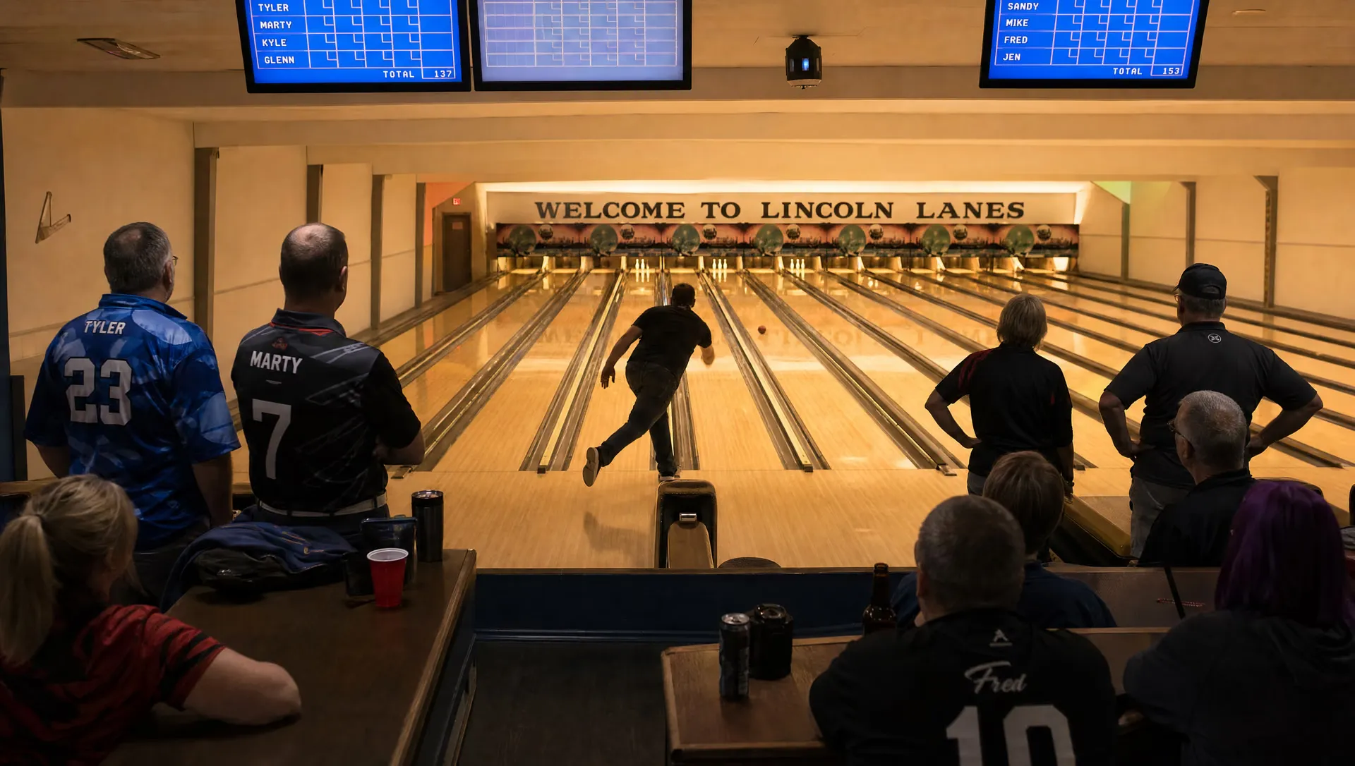 A league night on the lanes with bowlers in red team shirts under the Welcome to Lincoln Lanes sign