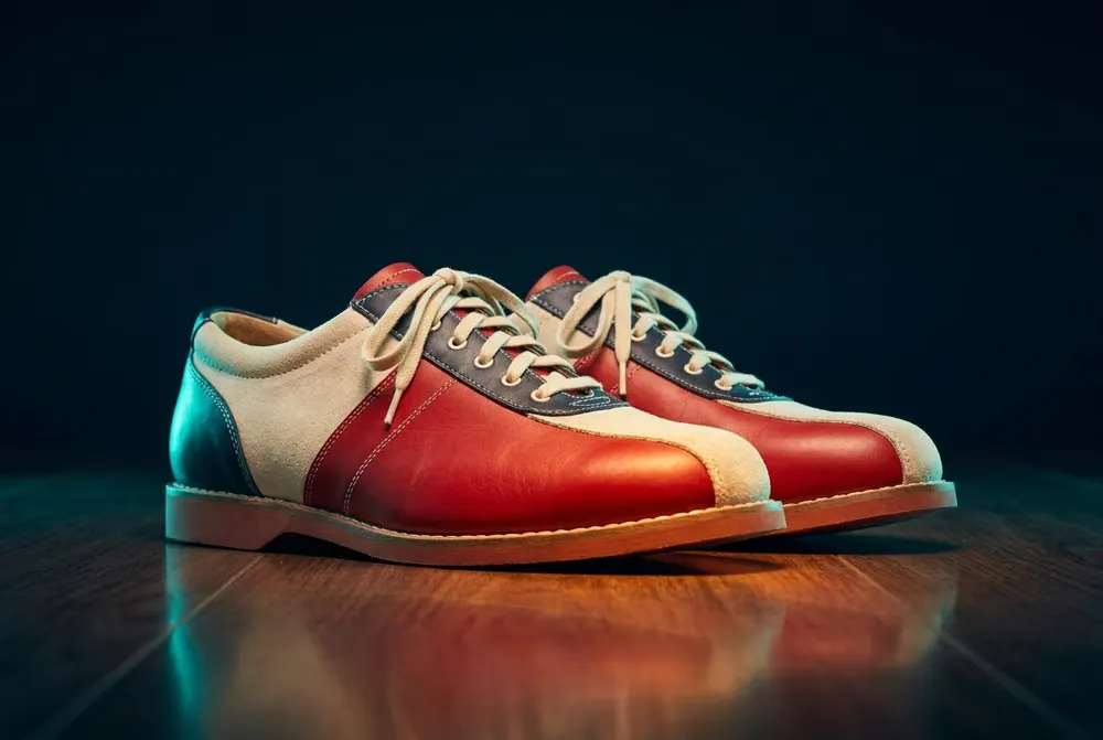 A pair of two-tone red, cream and navy bowling shoes